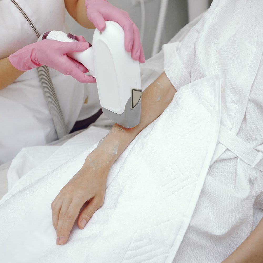 Cosmetologist use laser. Woman with cosmetologist. Lady in a beauty studio.