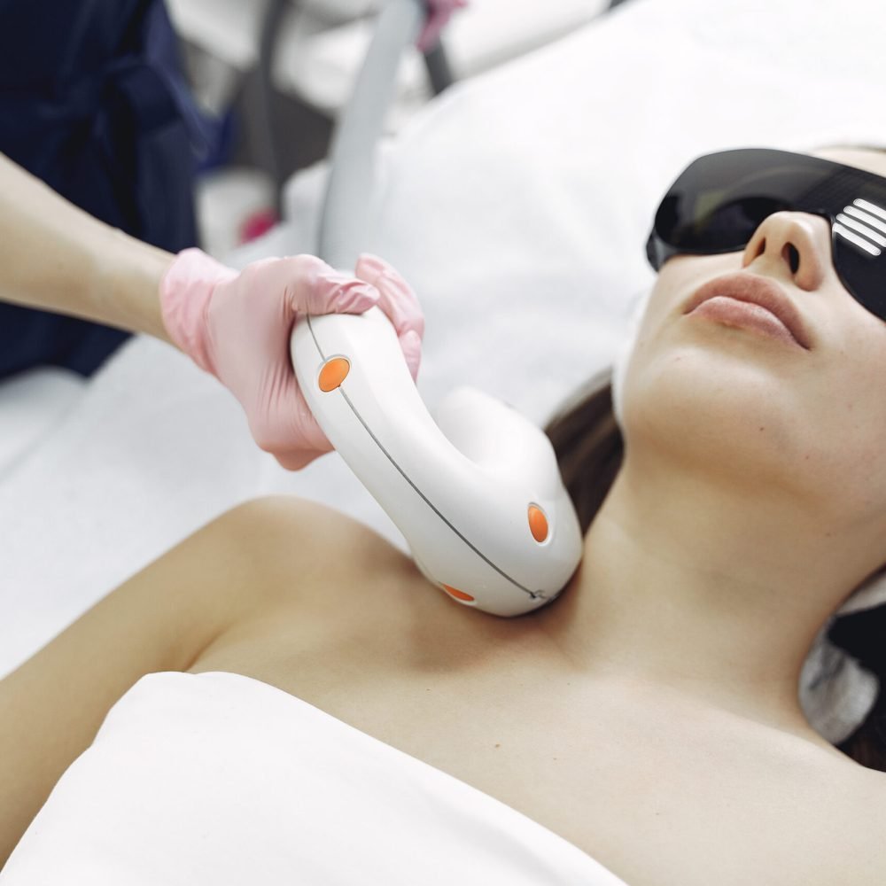 Cosmetologist use laser. Woman with cosmetologist. Lady in a beauty studio.